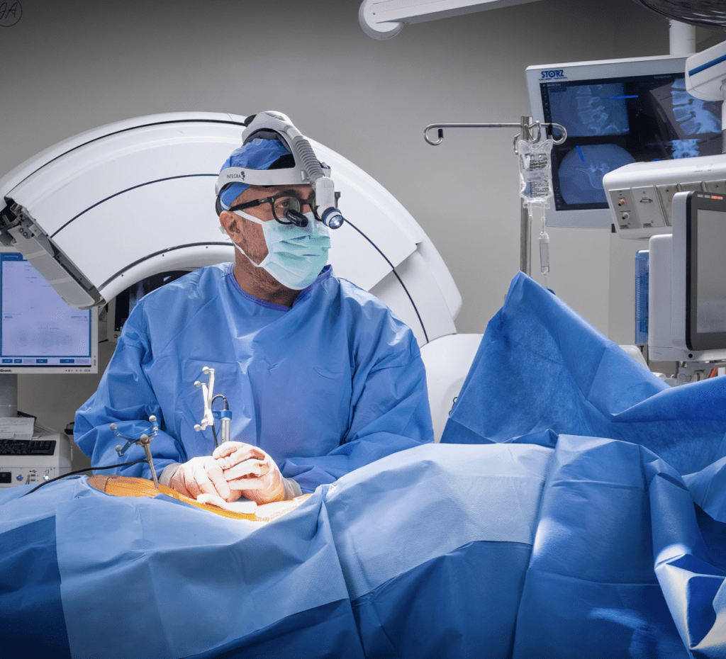 A surgeon in the operating room wearing blue scrubs.