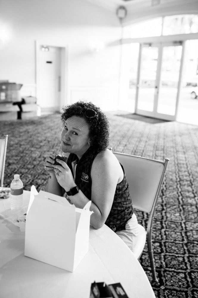 A woman sitting at the table with food in her hand.