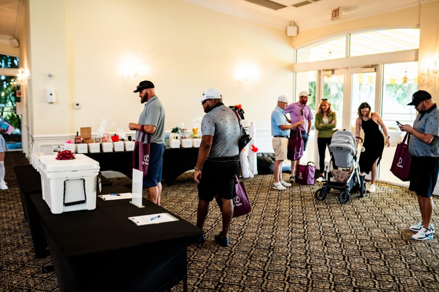 A group of people standing around tables with food.