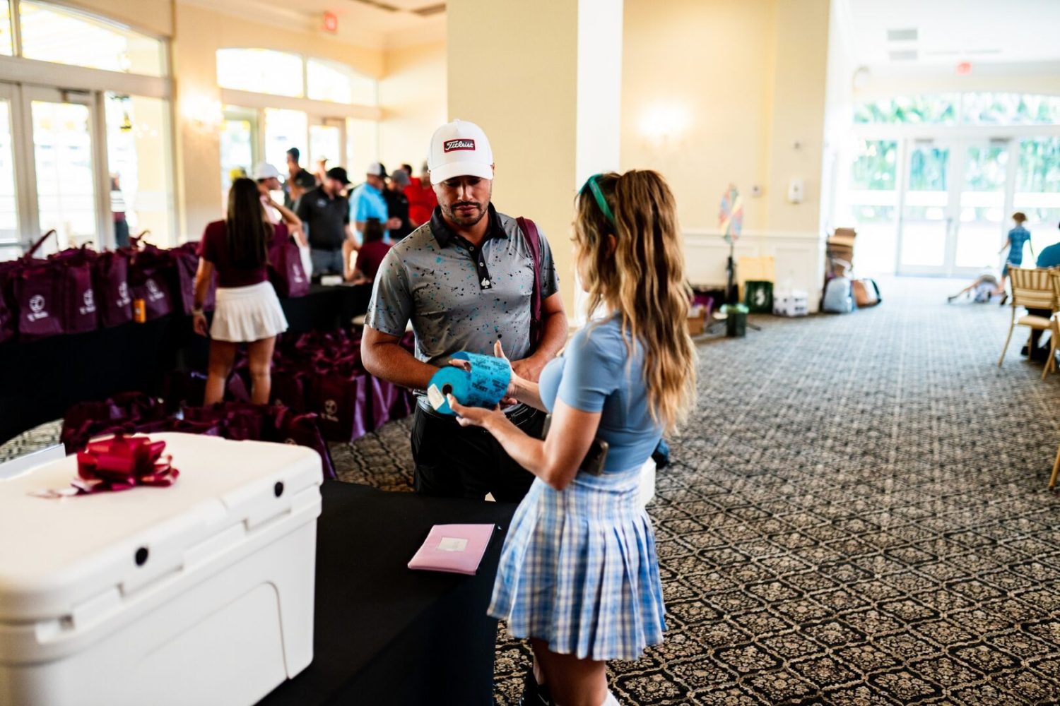 A man handing something to a girl in front of a room.