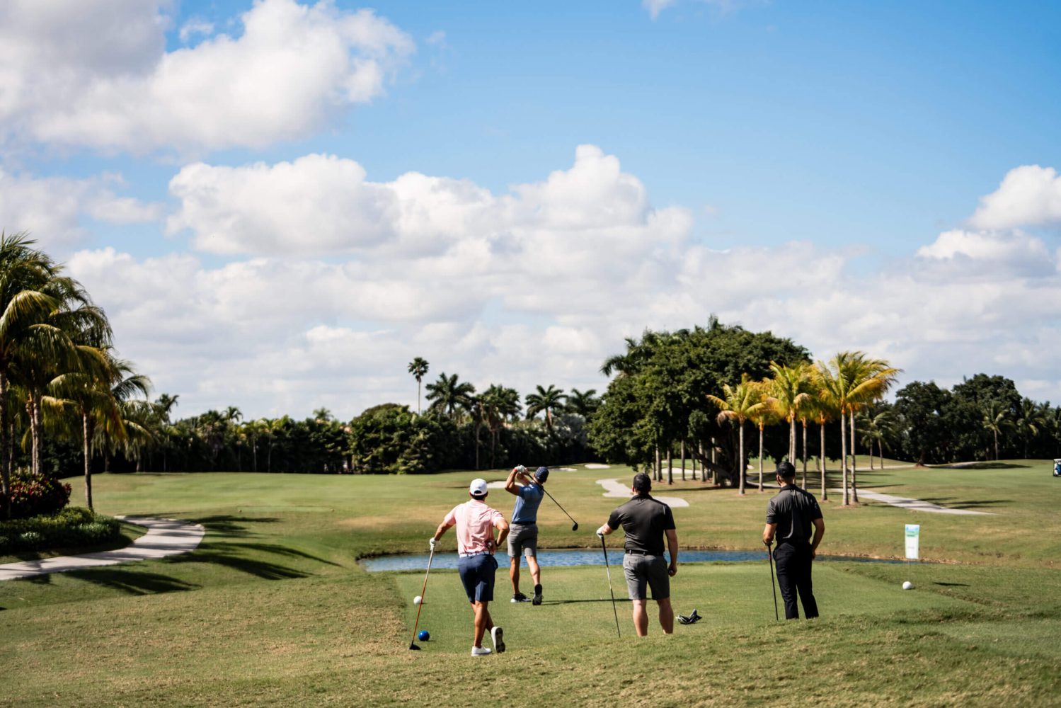 A group of people standing on top of a golf course.