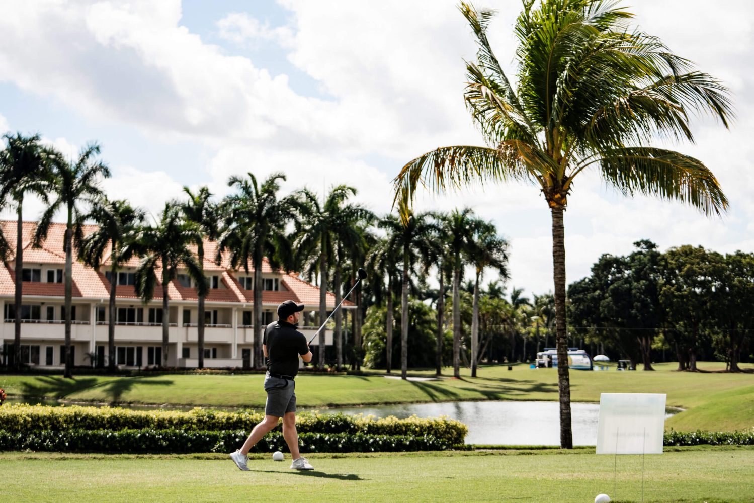 A man walking across the grass with a golf club.