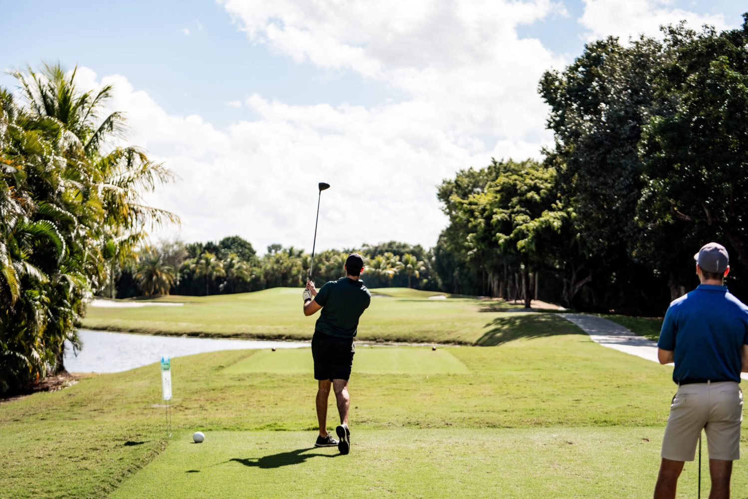 A man is swinging at the golf ball