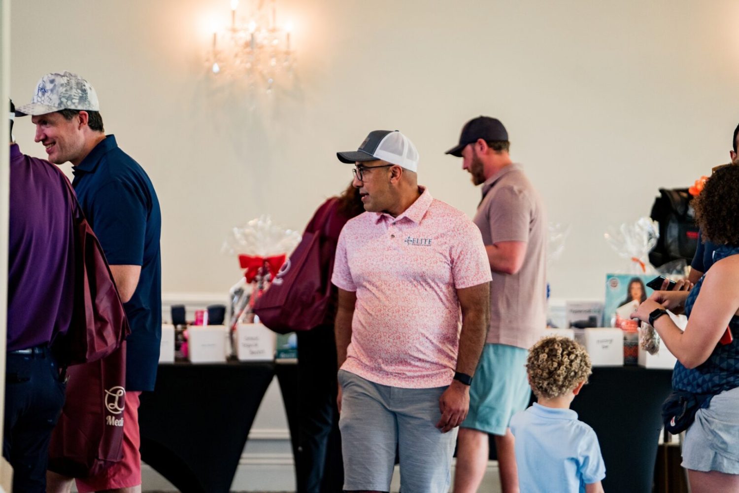 A group of people standing around in front of tables.