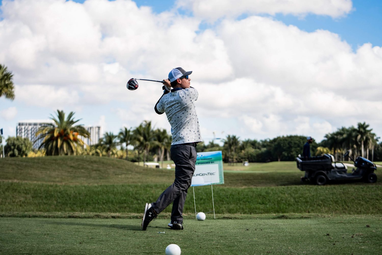 A man swinging a golf club on the course.
