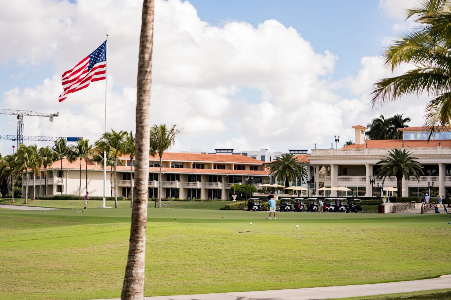 A large building with an american flag flying in the background.