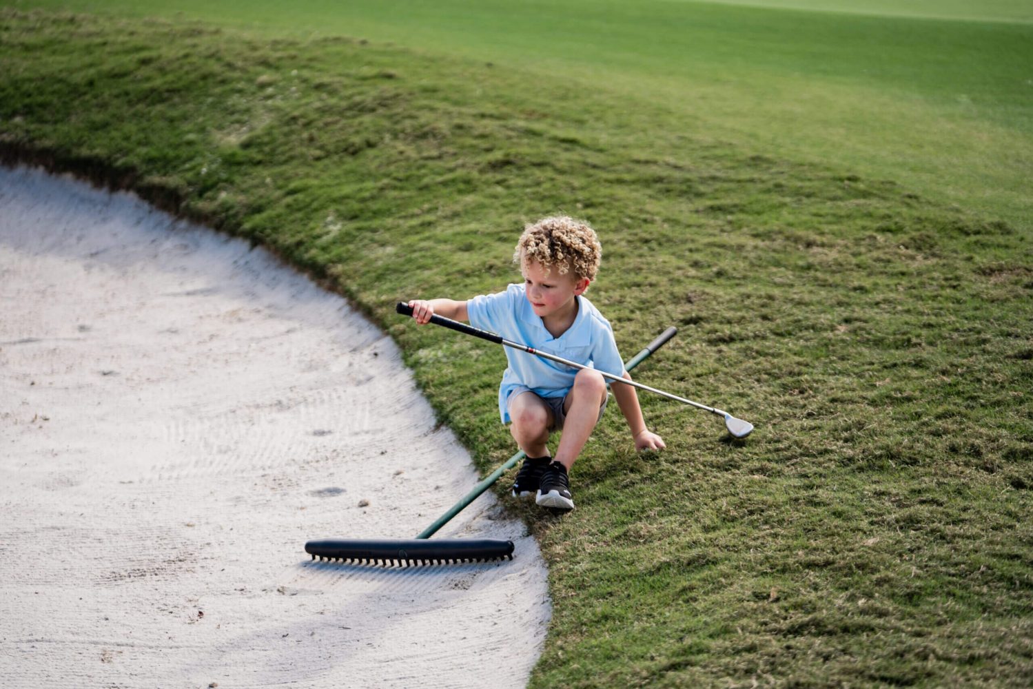 A young boy is playing golf on the course.