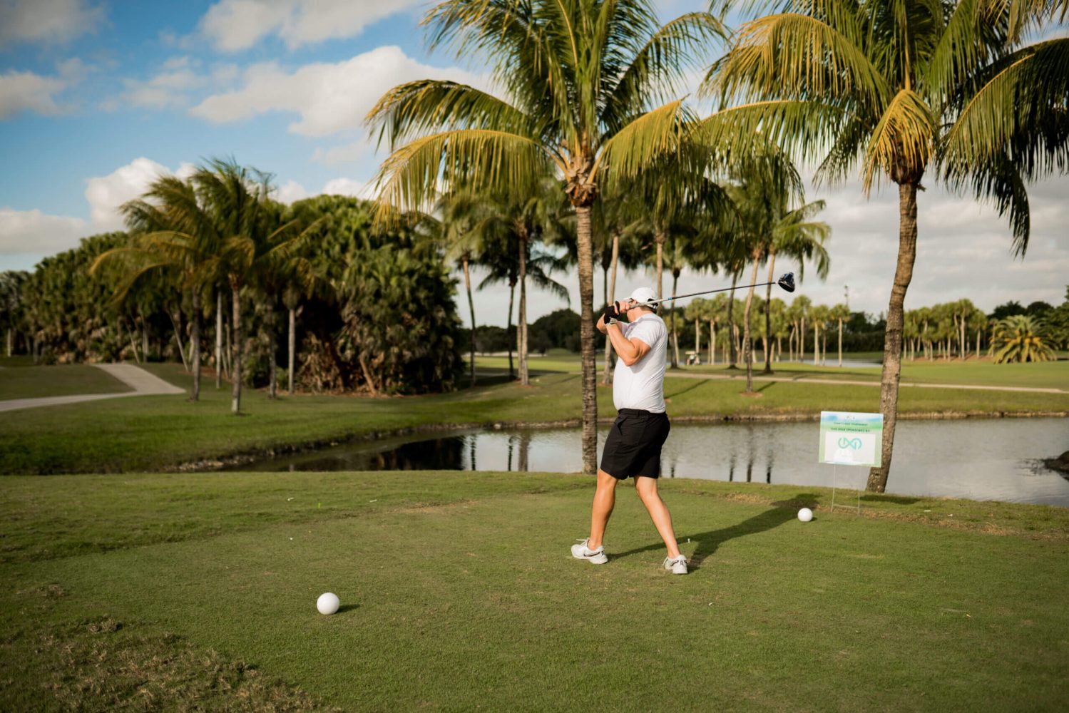 A man is swinging at the golf ball.