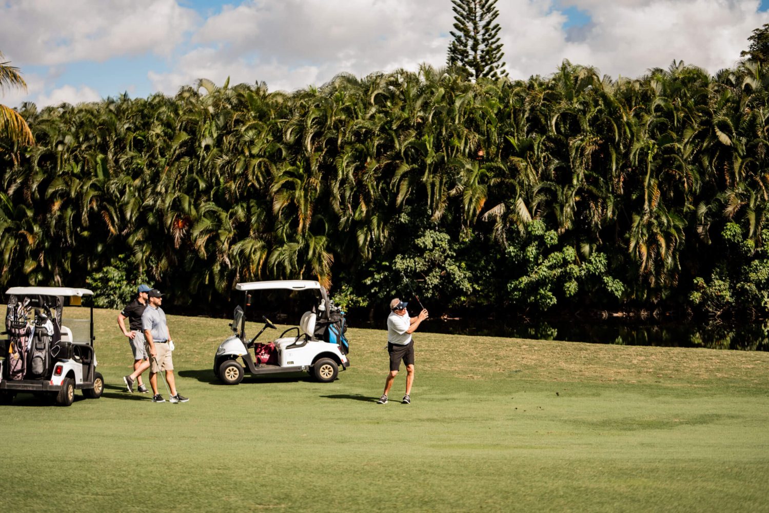 A group of people standing on top of a golf course.