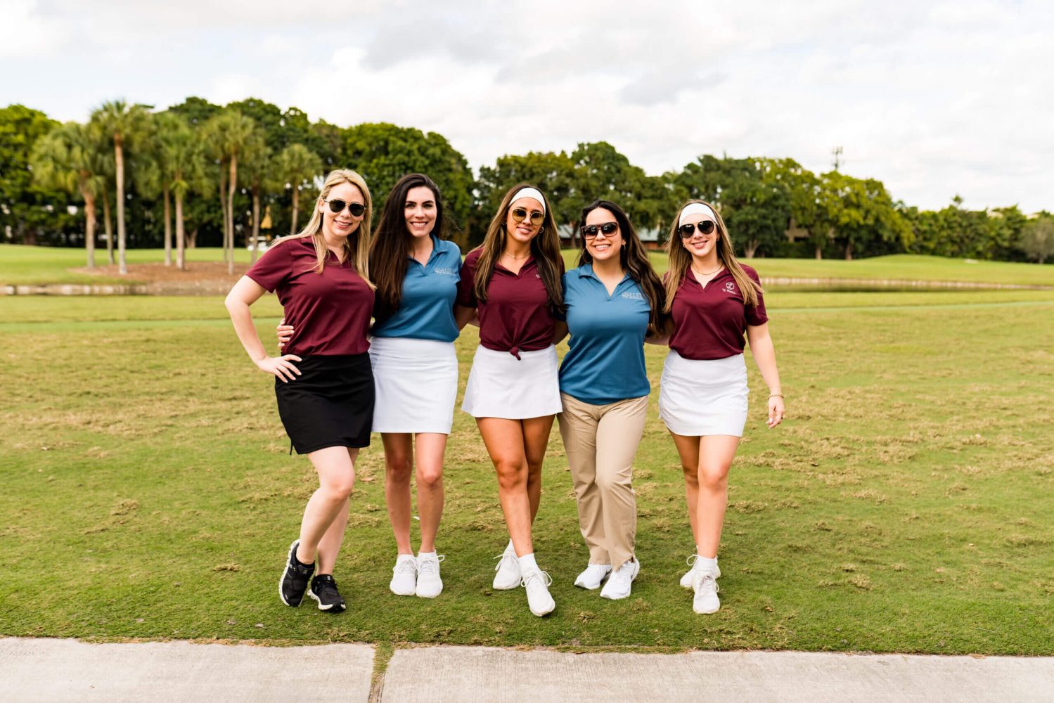 A group of women standing on top of a grass covered field.