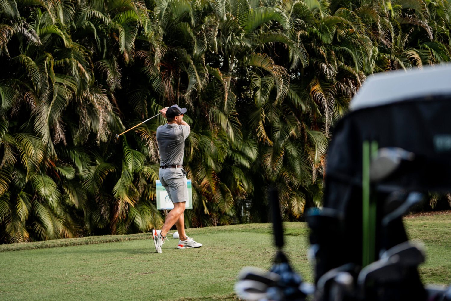 A man is swinging at the golf ball