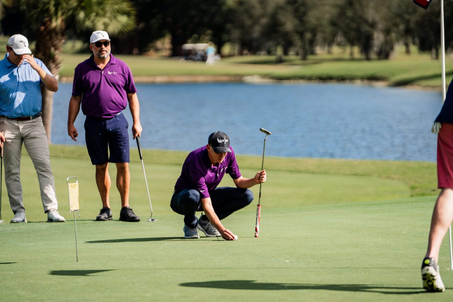 Two men are playing golf on a green.