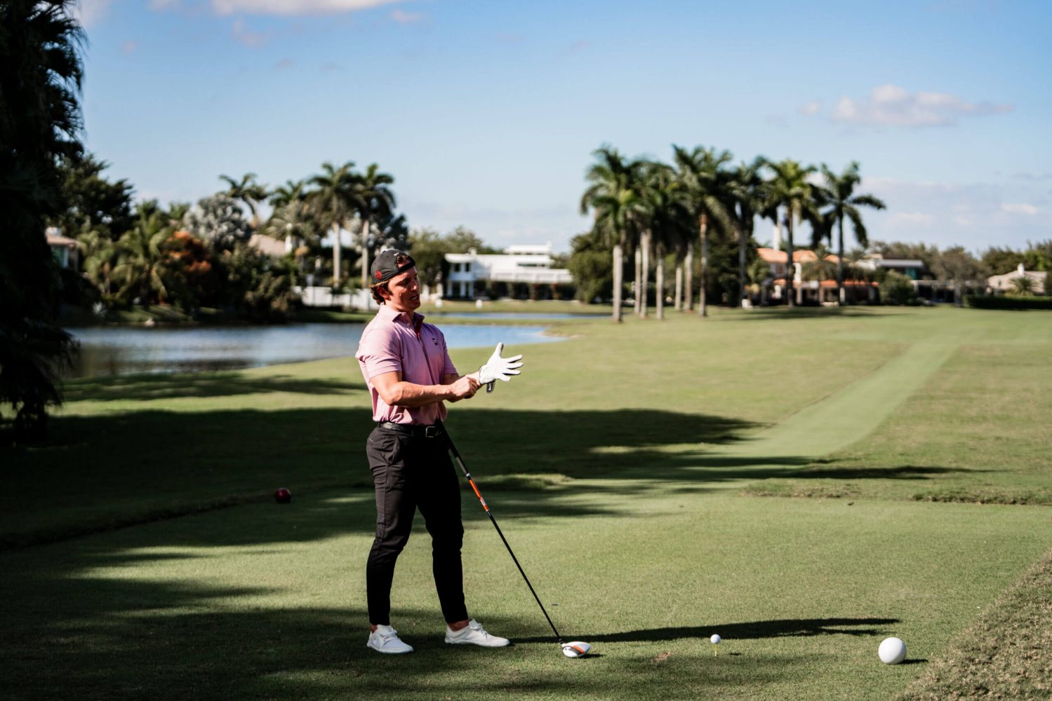 A man standing on top of a golf course holding onto a club.