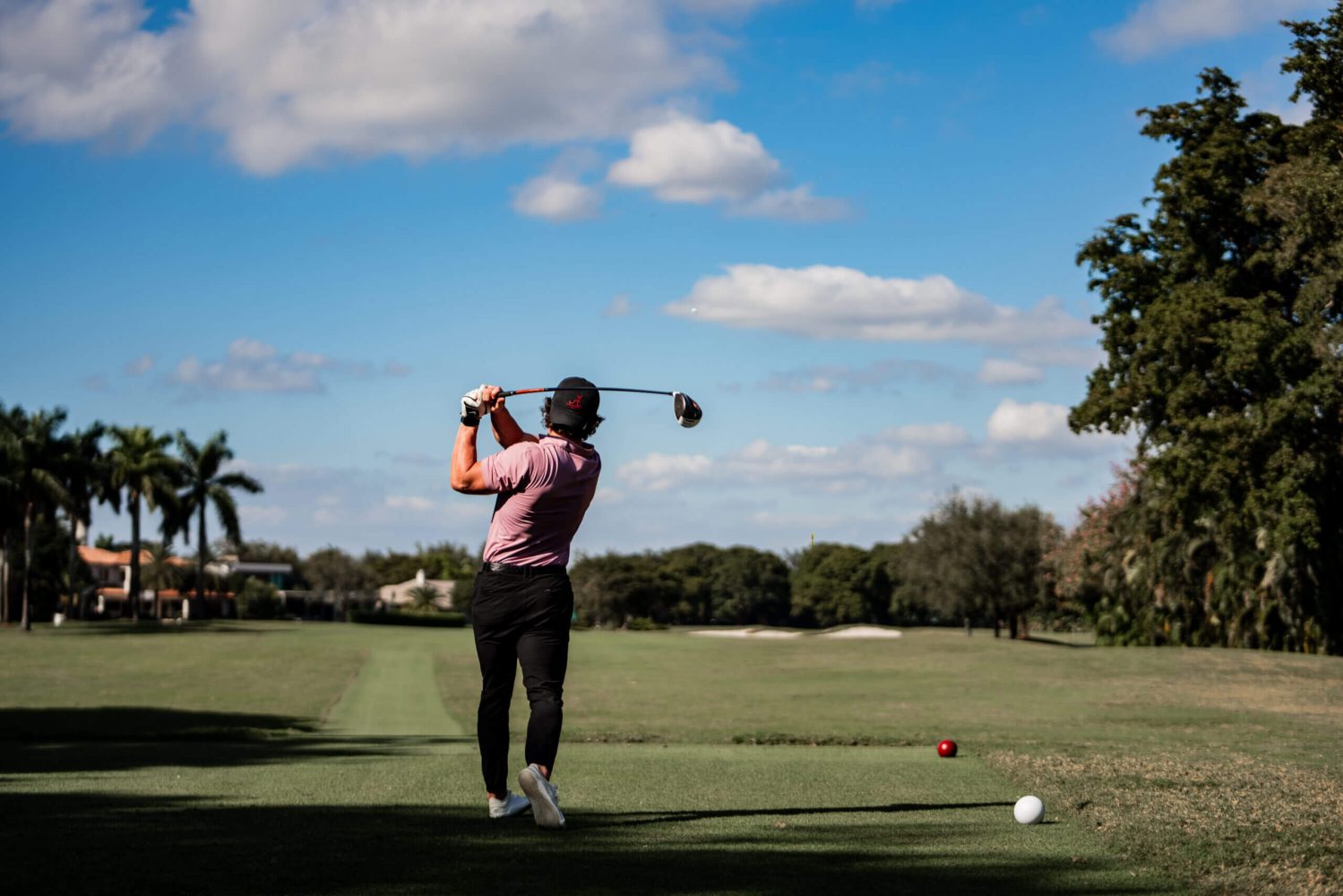 A man is swinging at the golf ball.