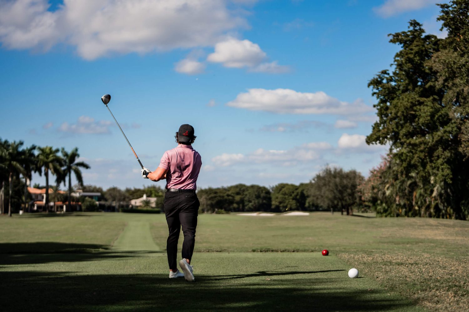 A man is swinging at the golf ball