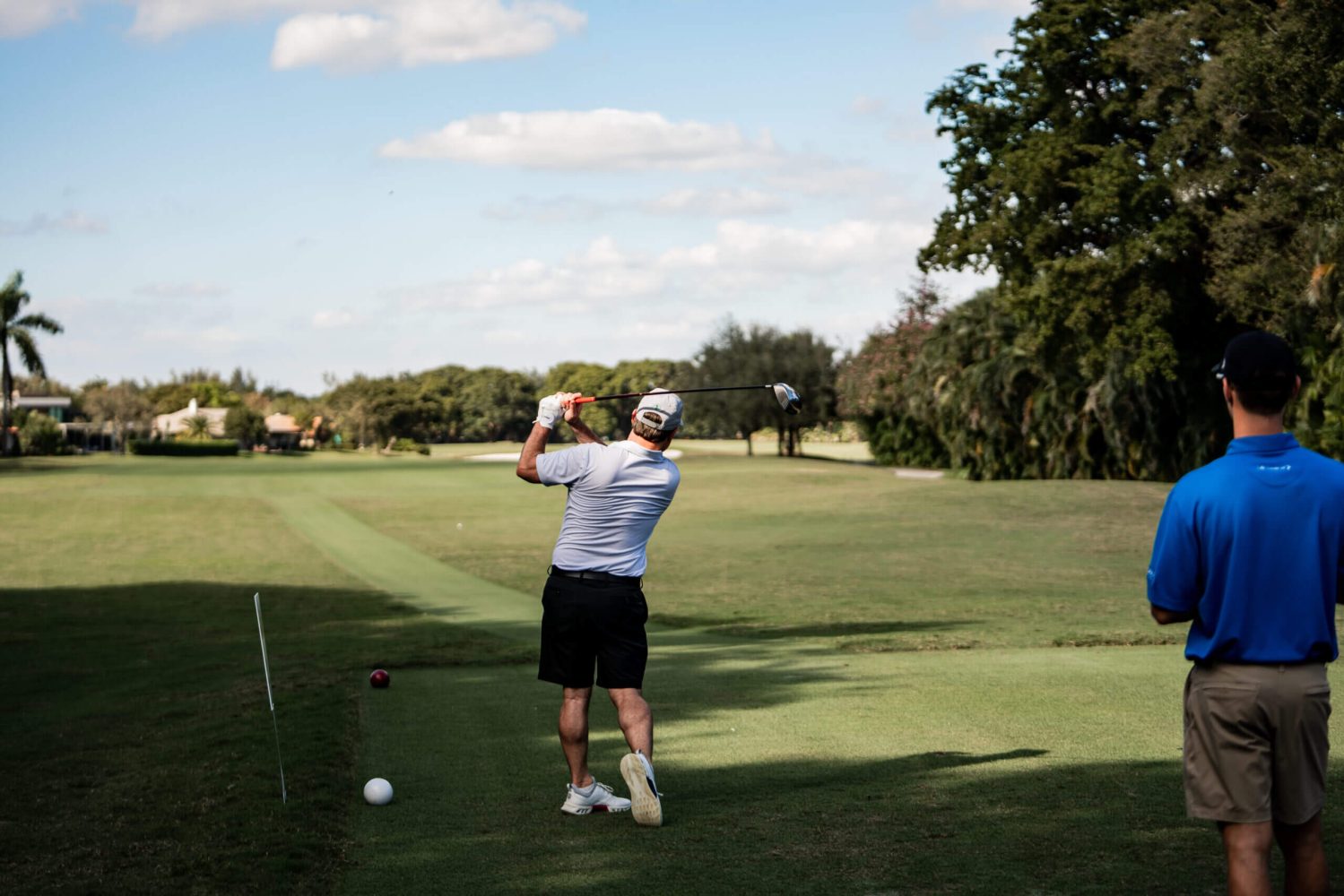 A man is swinging at the golf ball