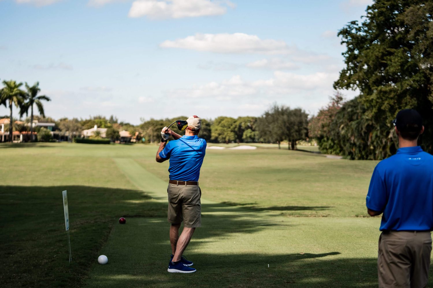 A man in blue shirt holding a golf club.