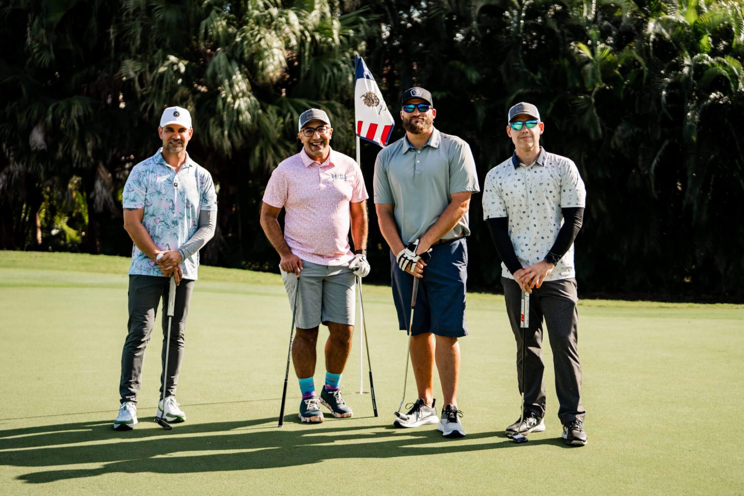 A group of men standing on top of a golf course.