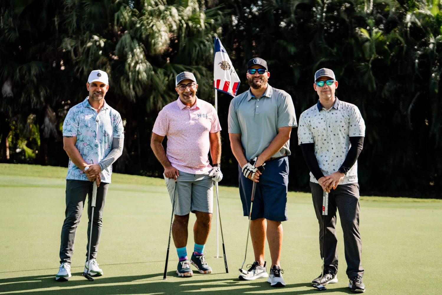 A group of men standing on top of a golf course.