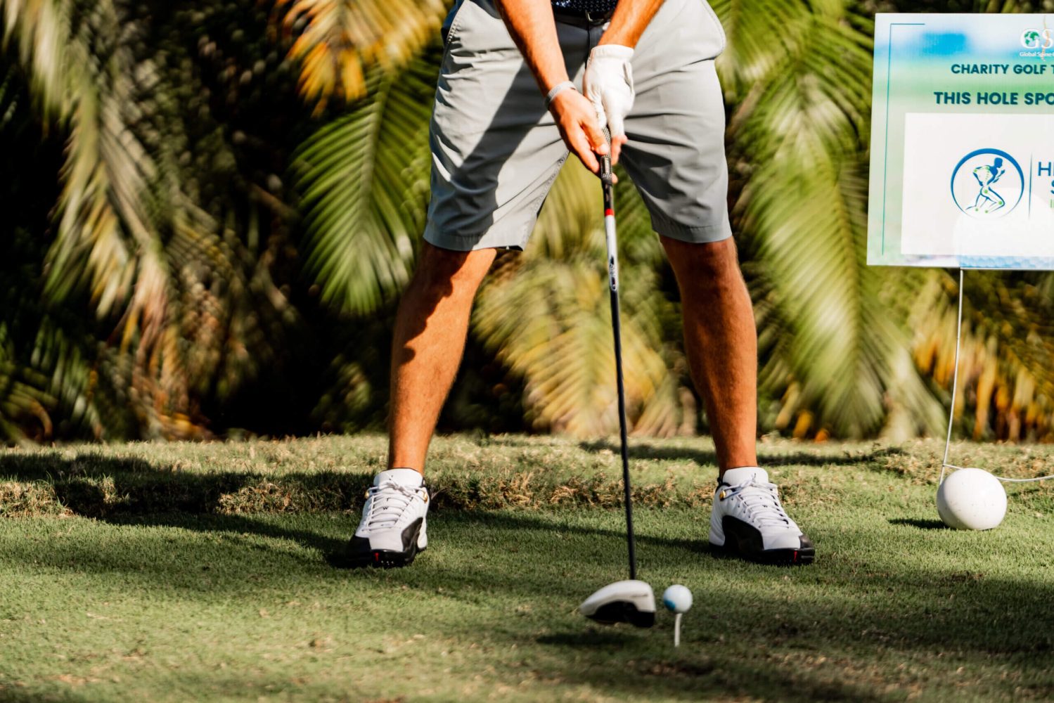 A person holding a golf club on top of a green.