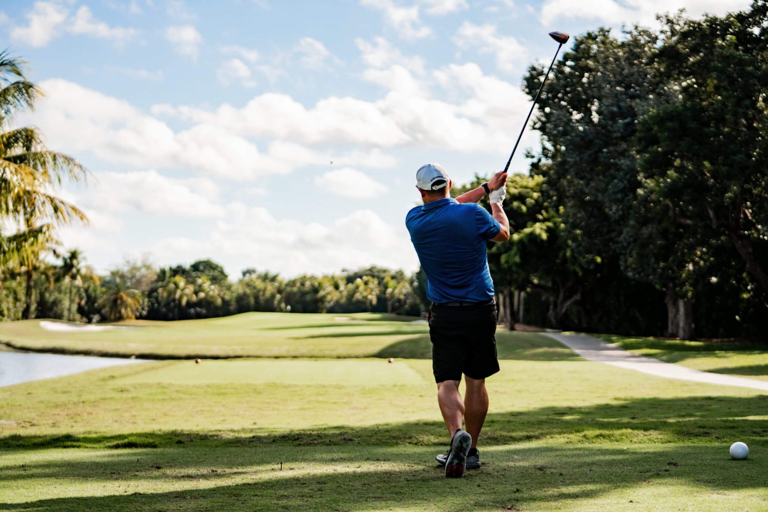 A man holding onto a golf club while standing on the course.