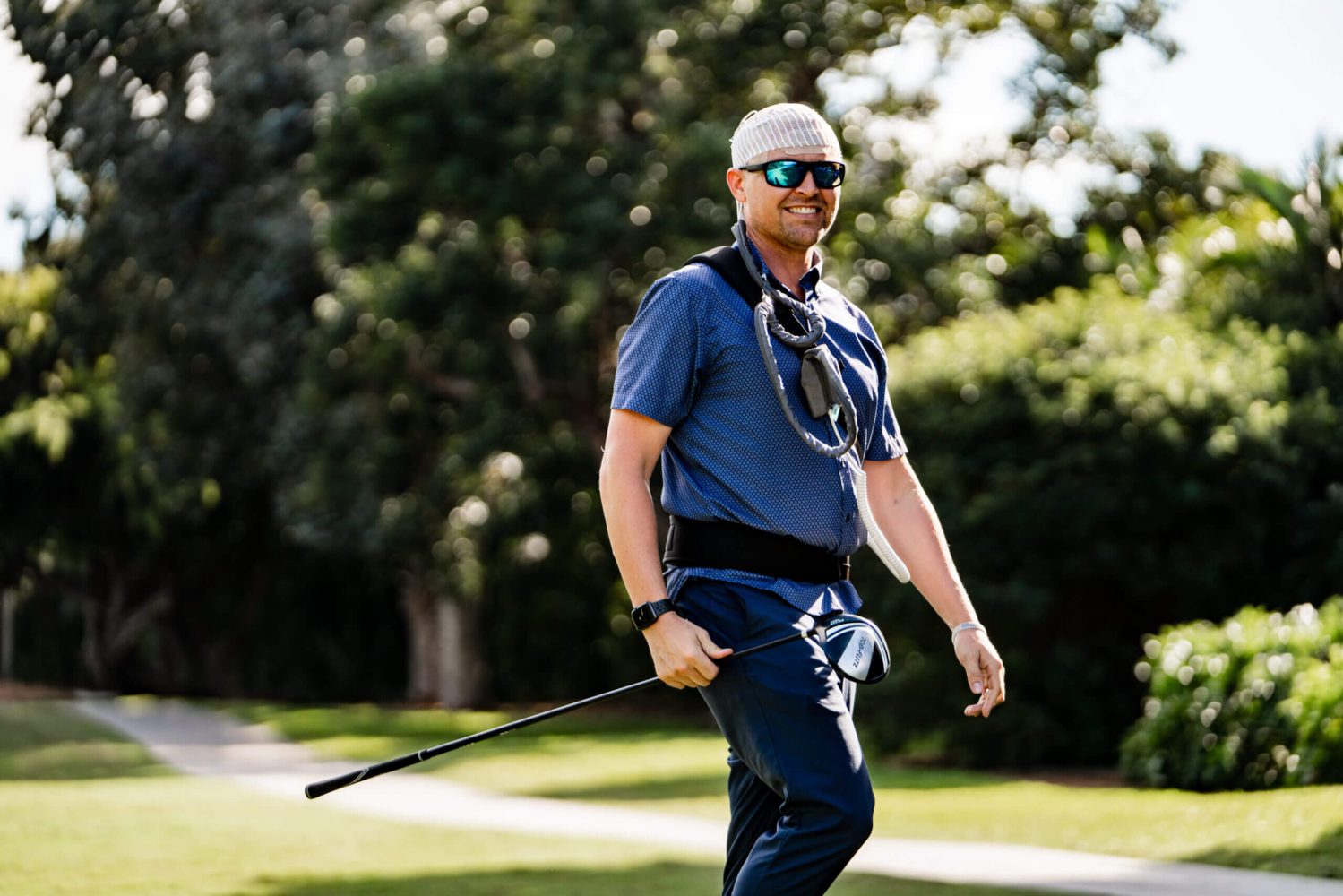 A man in blue shirt holding a stick.