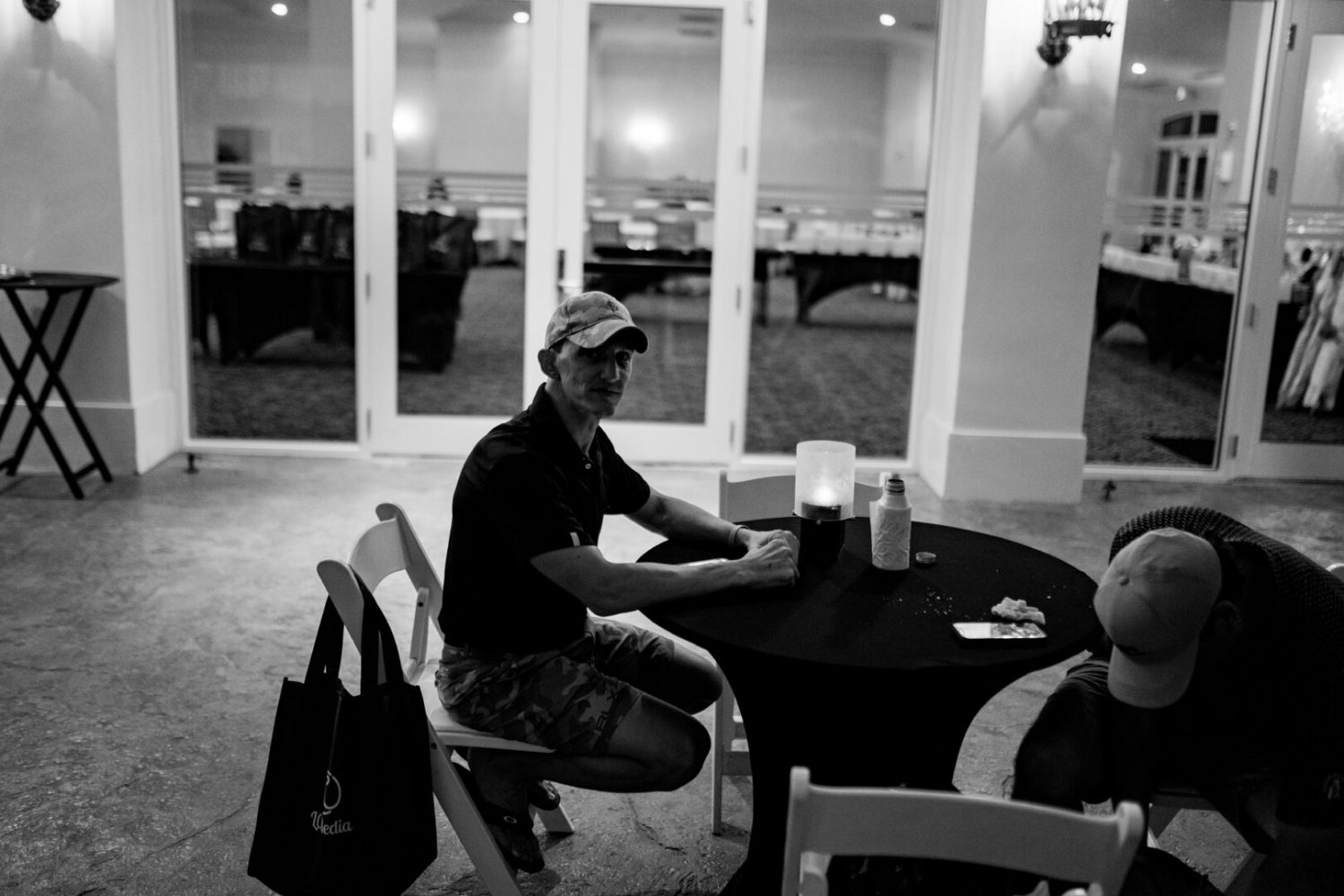 A man sitting at a table with two other people.