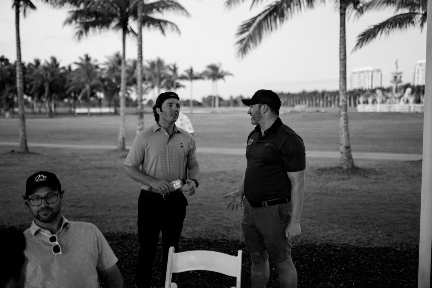 Two men standing next to each other in a park.