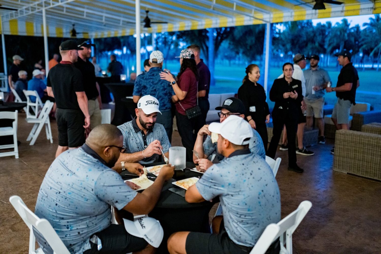 A group of people sitting at tables with plates.