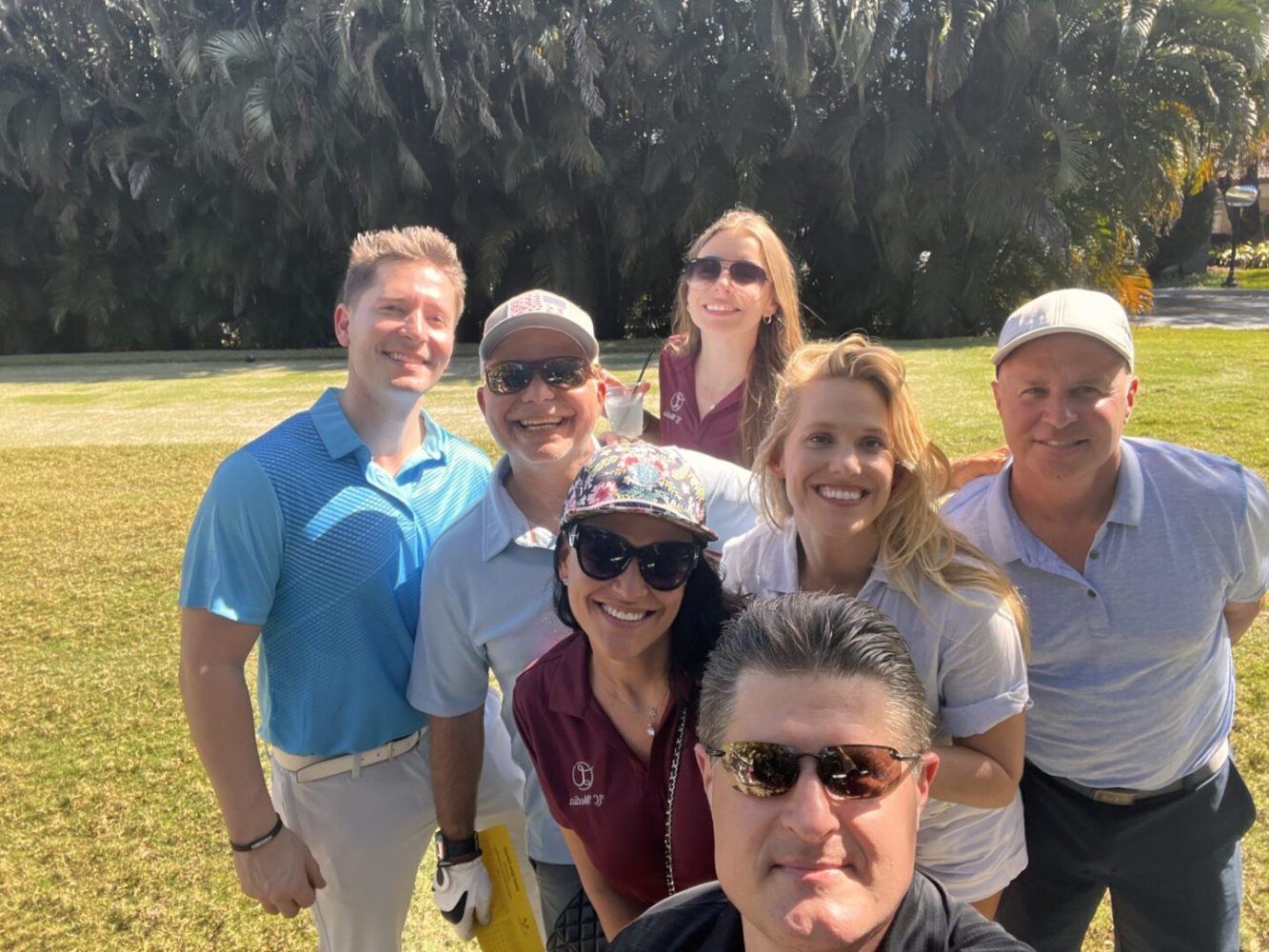 A group of people standing in the grass.