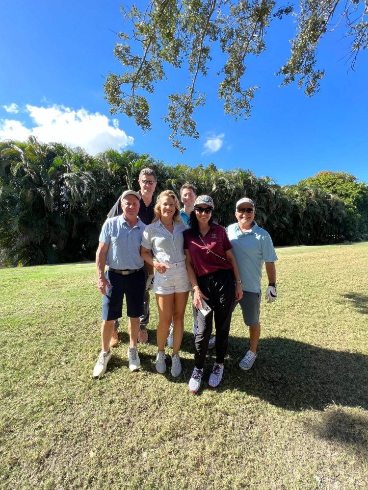 A group of people standing in the grass.