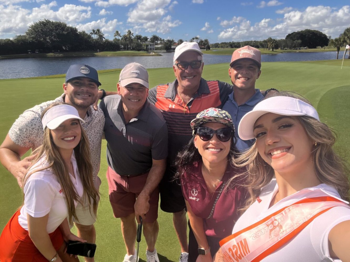 A group of people standing on top of a golf course.