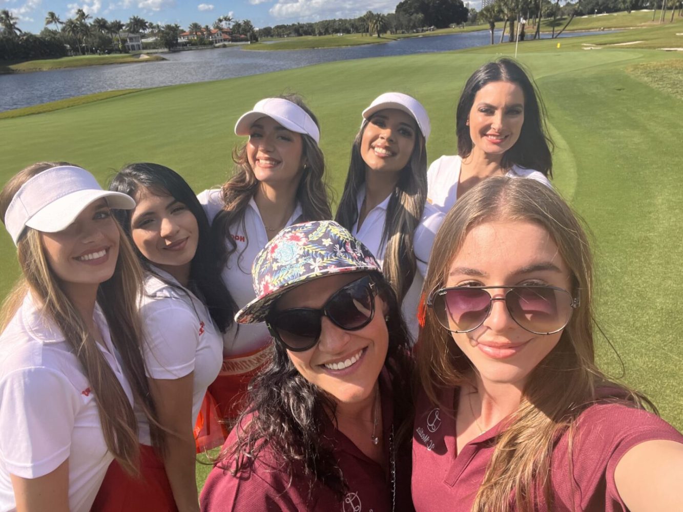 A group of women standing on top of a golf course.