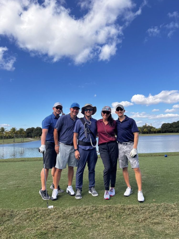 A group of people standing on top of a green.