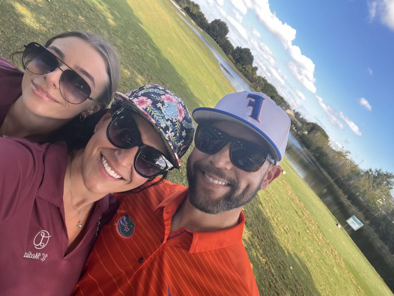 A man and two women are smiling for the camera.