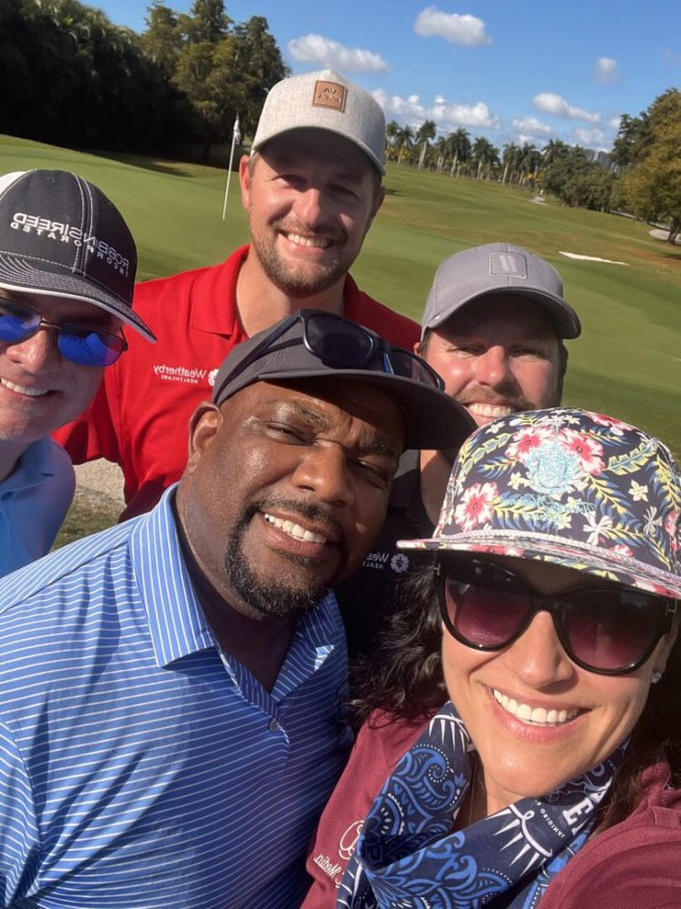 A group of people taking a selfie on the golf course.