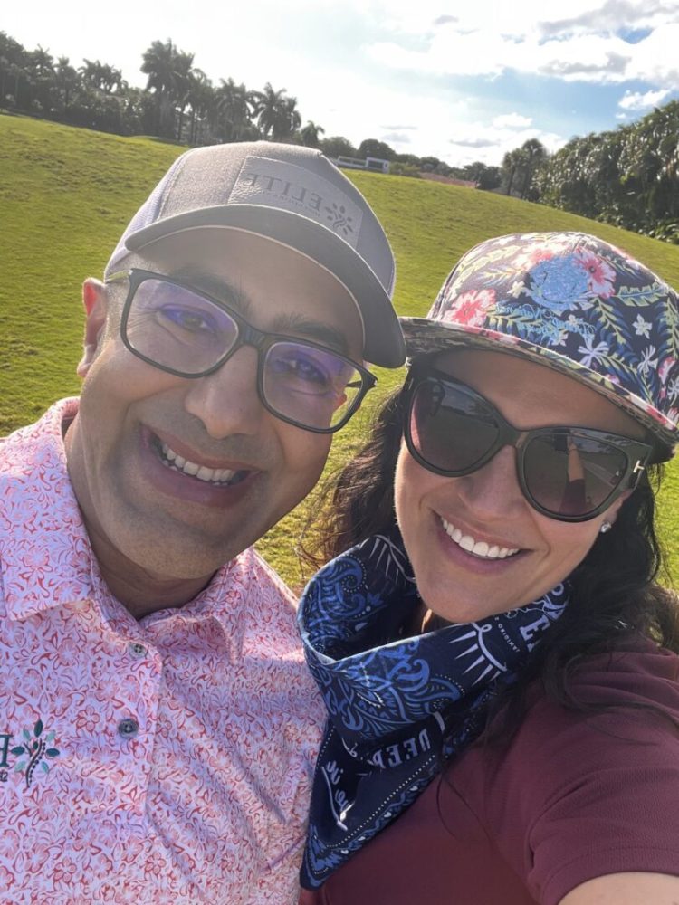 A man and woman standing in front of some grass.