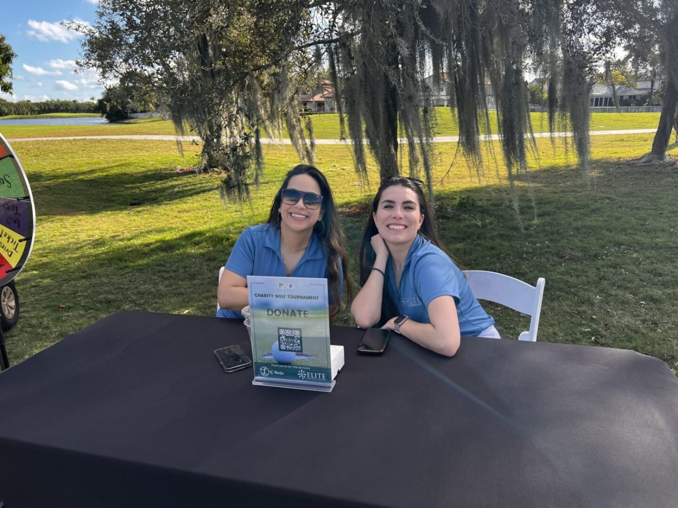 Two women sitting at a table with a book.