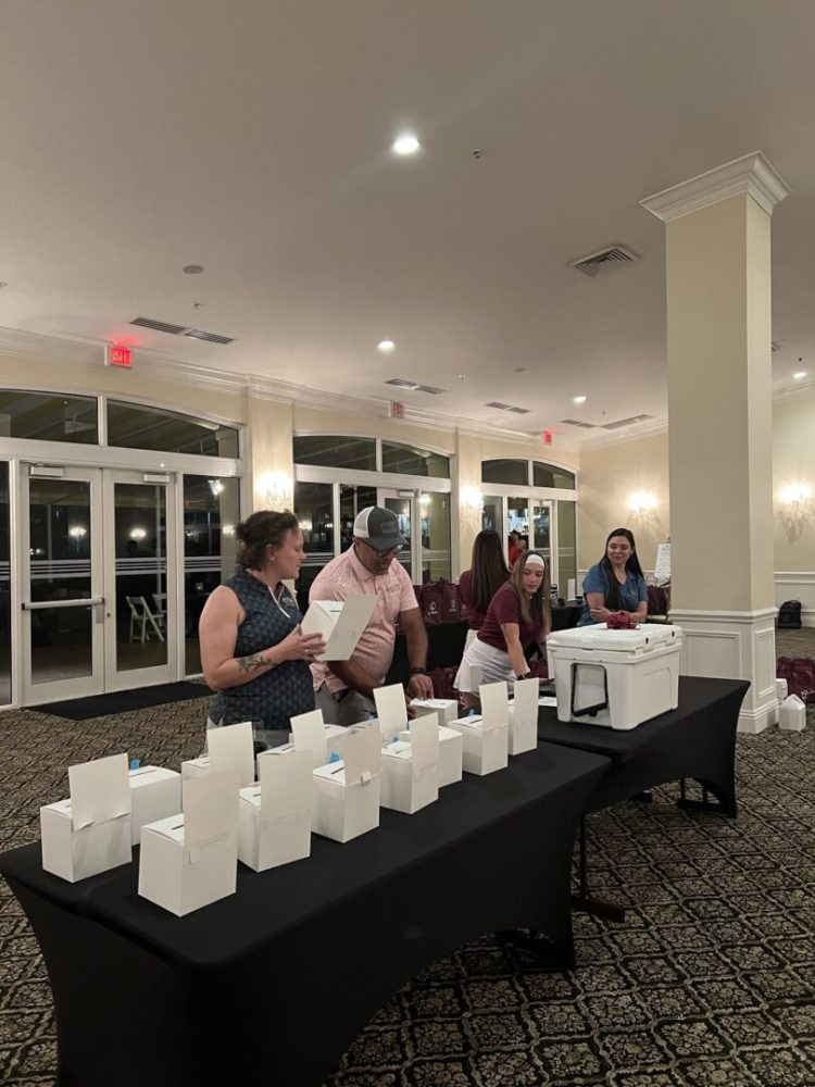 A group of people standing around a table with boxes.