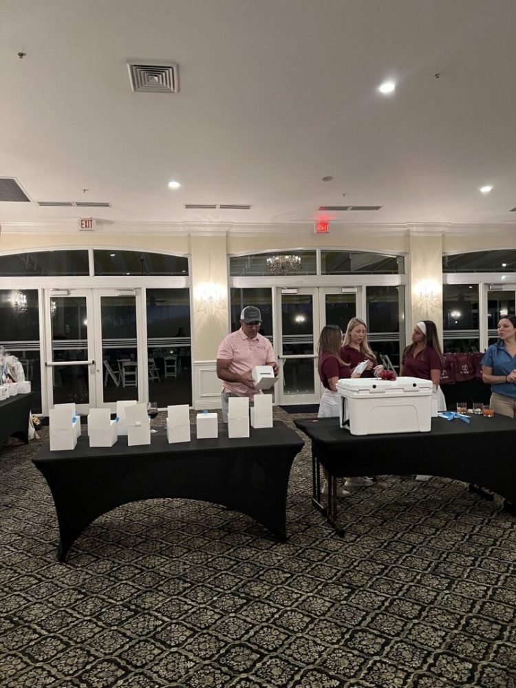 A group of people standing around tables with cups.